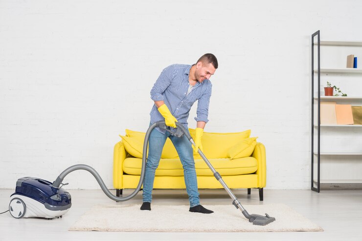 Man with vacuumed cleaning the room